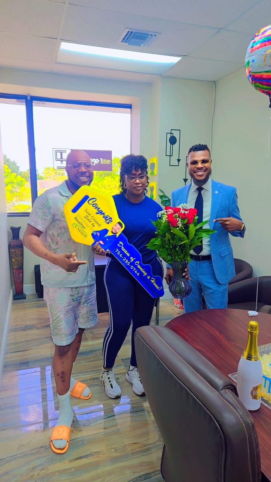 Ezechiel Obil celebrating a closing day with a client, presenting an oversized congratulations key